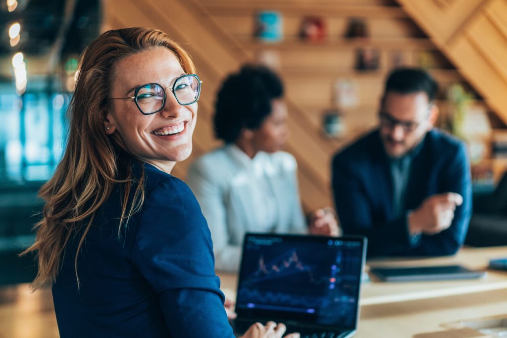 Mulher sorrindo analisando dados no computador