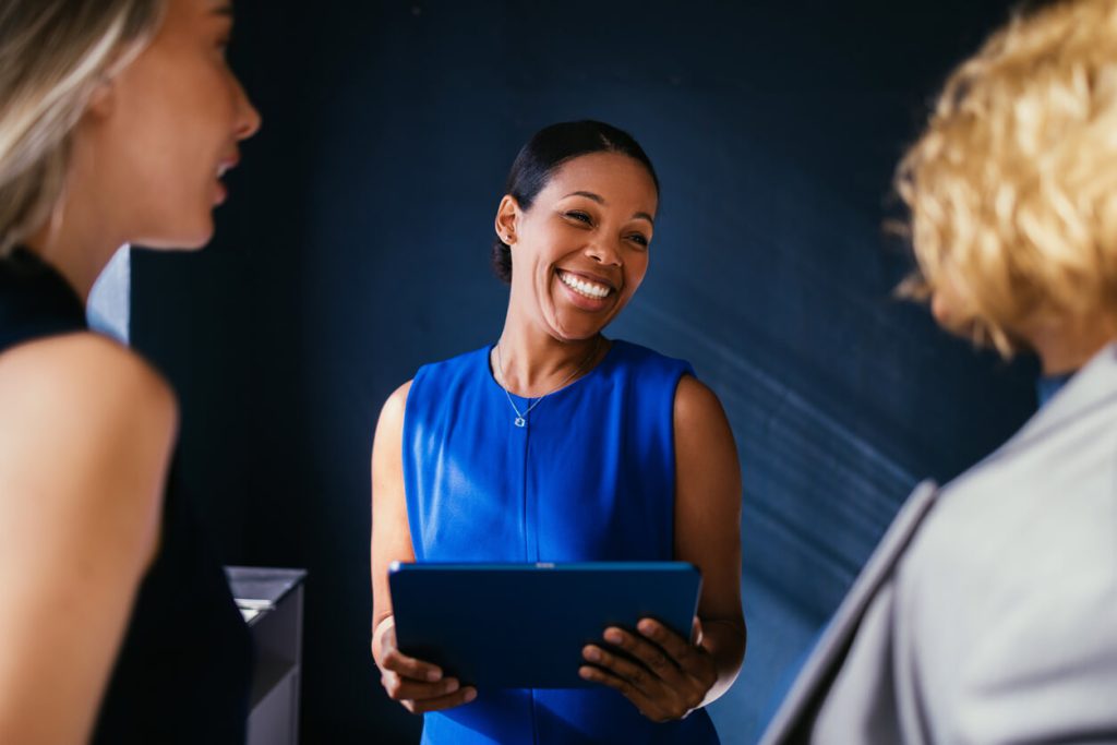 Mulher segurando o tablet e sorrindo