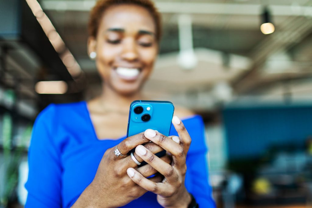 Mulher sorridente utilizando o celular