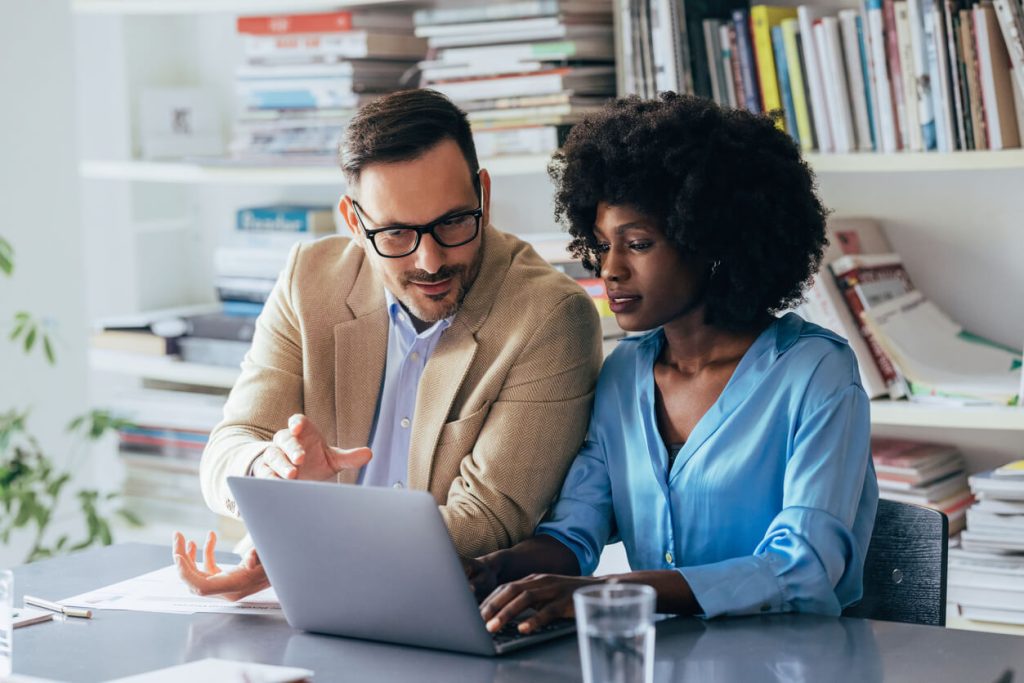 Homem e mulher analisando uma tela de computador