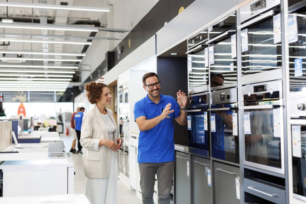 Vendedor mostrando um produto para a cliente.