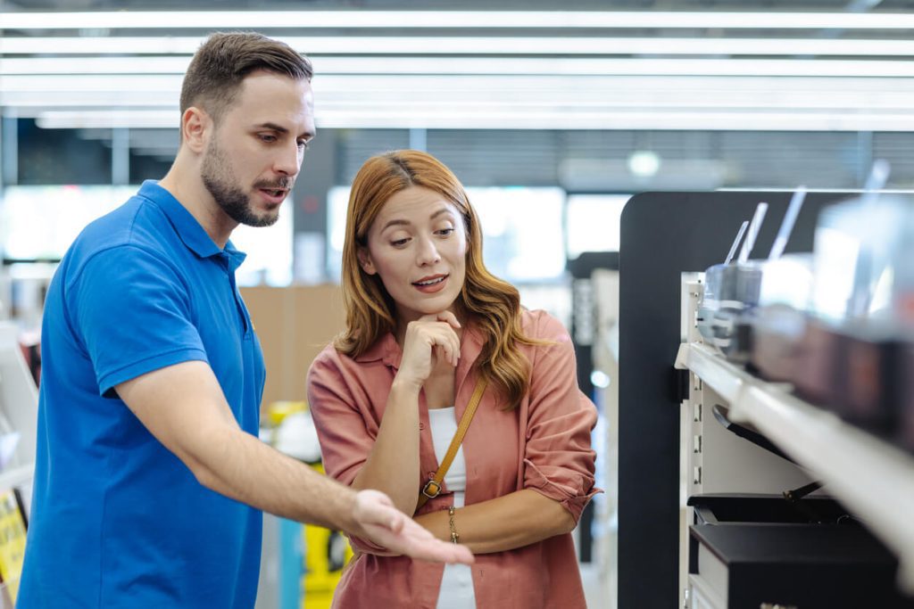 Vendedor mostrando os produtos para uma consumidora