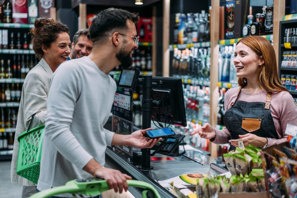 Homem fazendo o pagamento da compra dentro do supermercado